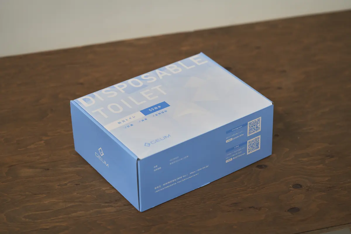 届いた携帯トイレ50回分の箱。机の上に置かれた青い箱で、A4より少し大きい程度の大きさ。