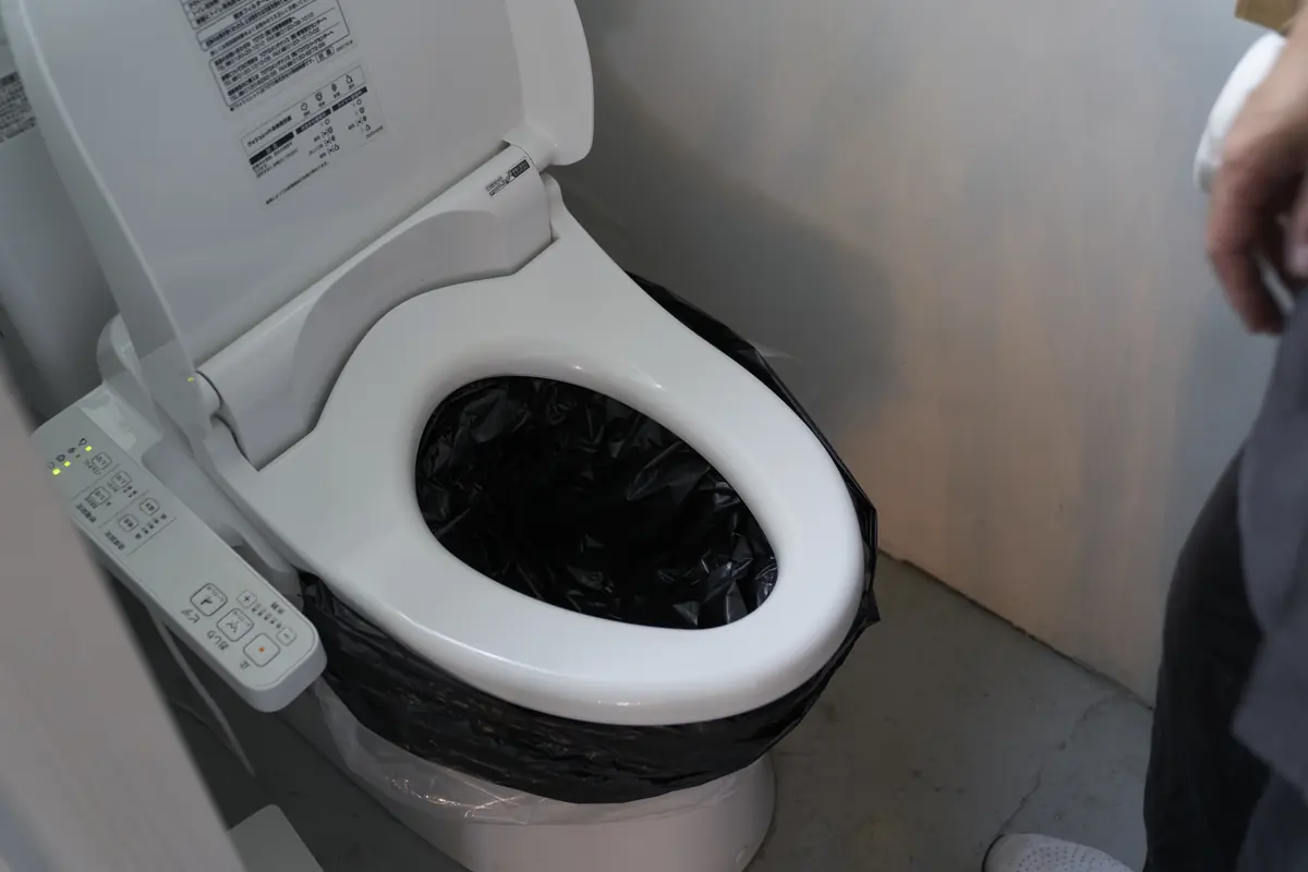養生シートの上から黒い便袋をかけ、便座を下ろした状態。
